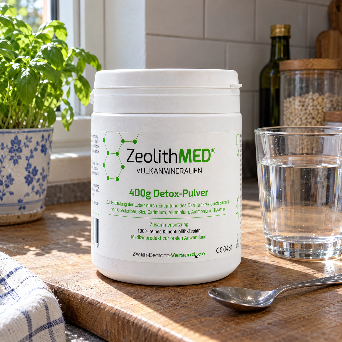 ZeolithMED Detox-Pulver auf einer Küchentheke mit Wasserglas und Teelöffel