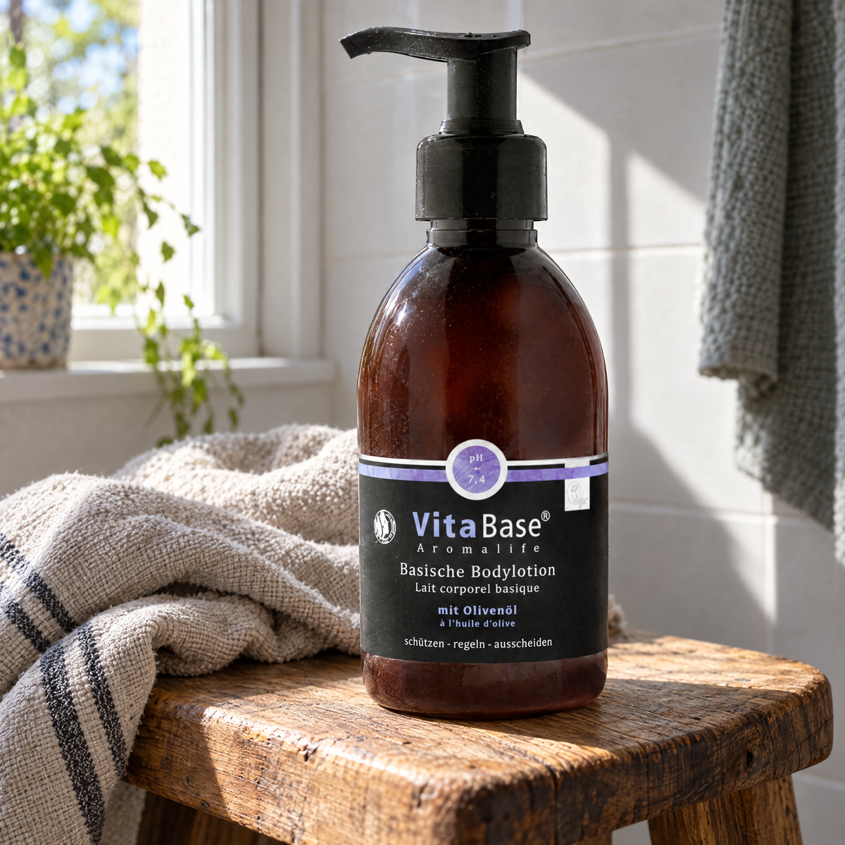 VitaBase Basische Bodylotion mit Olivenöl 500 ml – auf einem Holzhocker mit Leinentuch