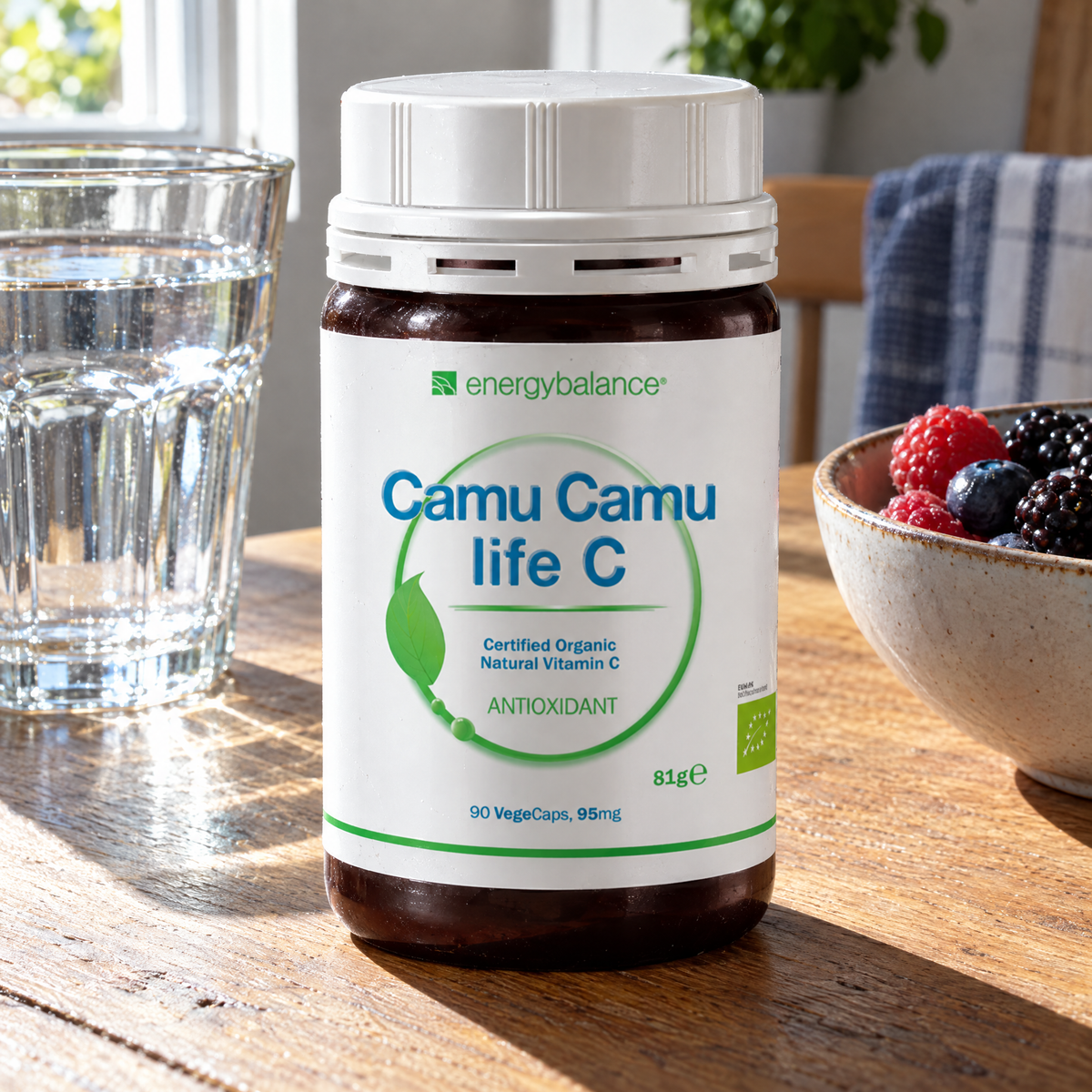 Energy Balance BIO CamuCamu Life 90 VegeCaps – auf dem Küchentisch mit Wasserglas und Beeren