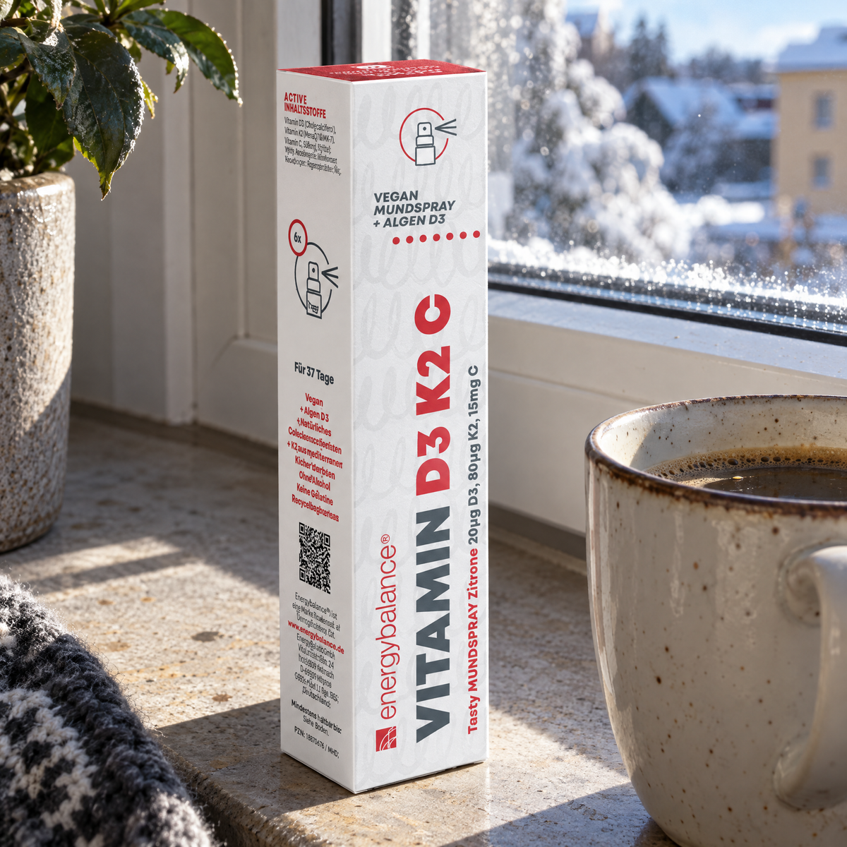 Energy Balance Vitamin D3 + K2 + C Mundspray 25 ml – auf einer Fensterbank neben einer Kaffeetasse