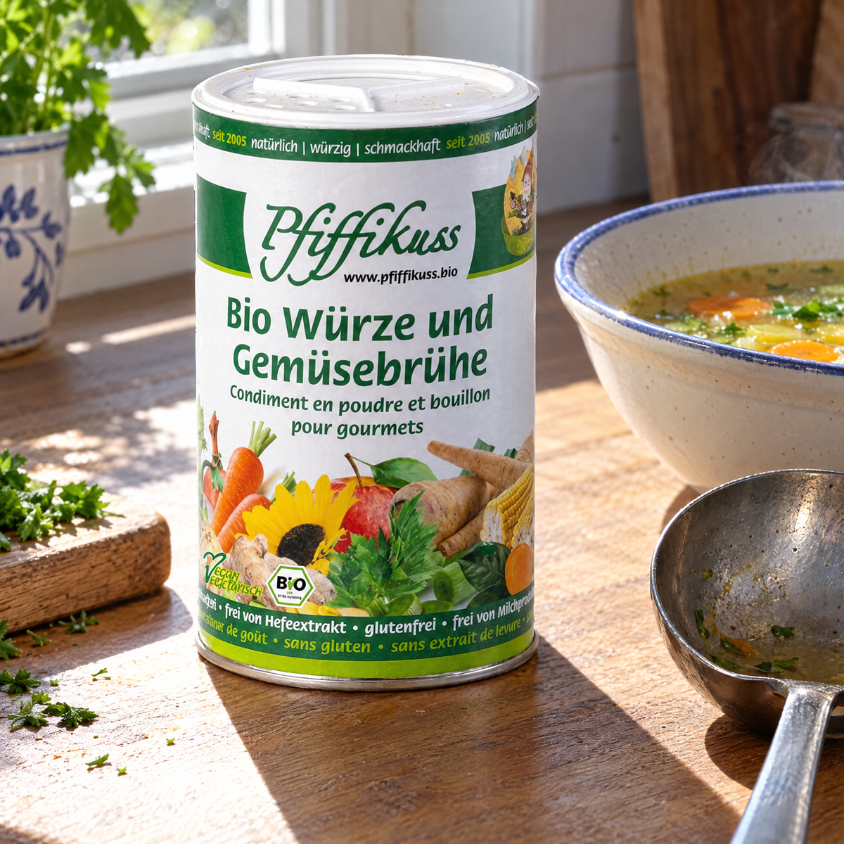 Pfiffikuss BIO Würze & Gemüsebrühe 250 g Streudose – auf der Küchenarbeitsfläche neben Suppenschale und Kelle