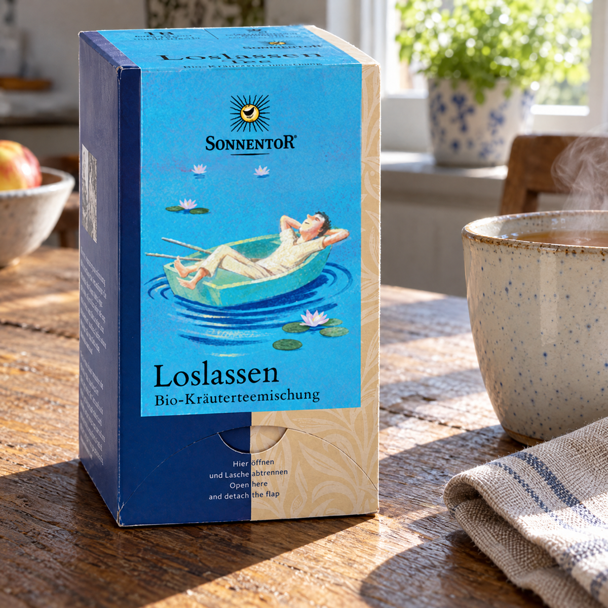 Sonnentor BIO Loslassen-Kräutertee 18 Beutel – auf dem Küchentisch neben einer dampfenden Tasse