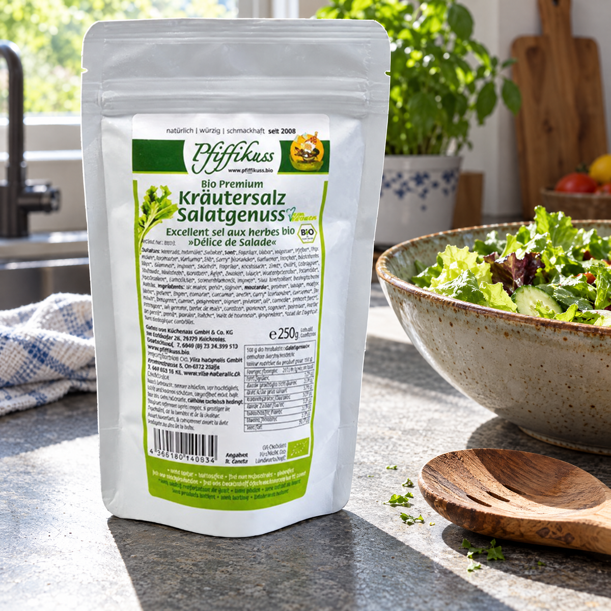 Pfiffikuss BIO Kräutersalz Salatgenuss 250 g – auf der Küchenarbeitsfläche neben einer Schüssel Blattsalat