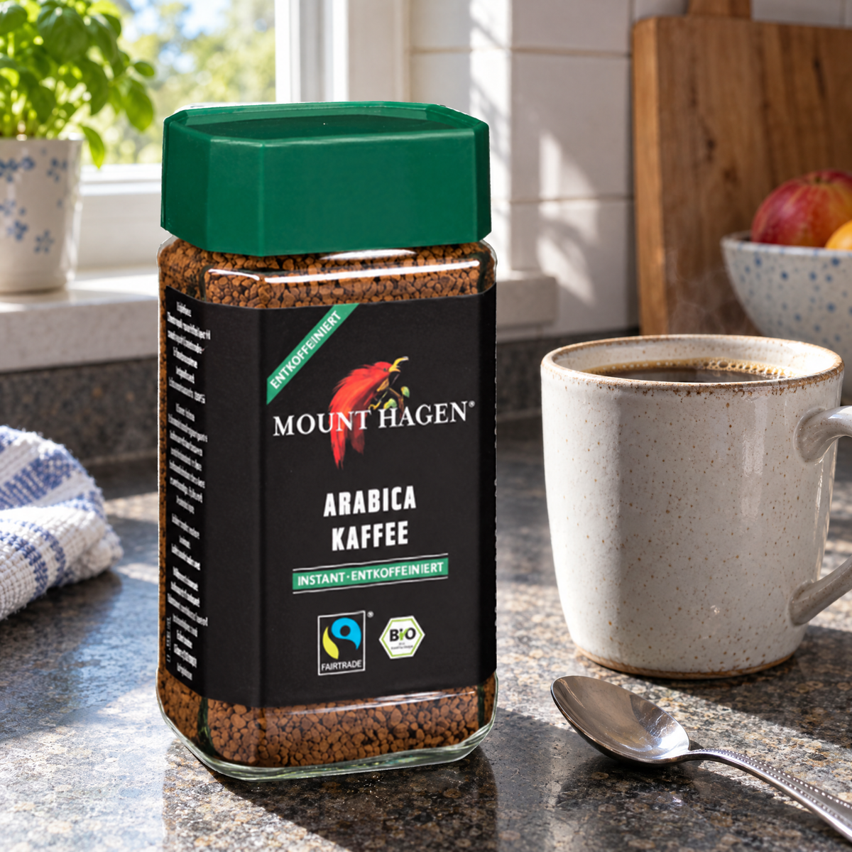 Mount Hagen BIO Bohnenkaffee löslich entkoffeiniert, 100 g Glas – auf der Küchenablage neben einer gefüllten Kaffeetasse