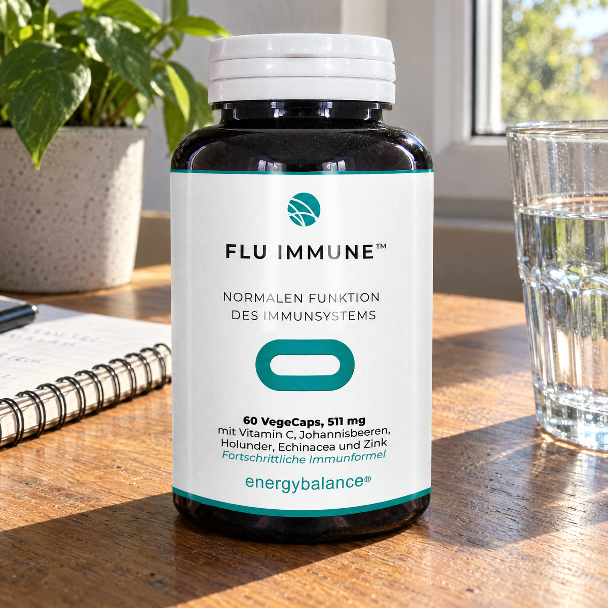Energy Balance Flu Immune Natural Complex, 60 VegeCaps – auf einem Holztisch neben einem Notizbuch und einem Glas Wasser