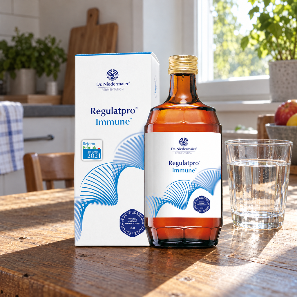 Dr. Niedermaier Regulatpro Immune, 350 ml – auf dem Küchentisch neben einem Glas Wasser, Flasche und Karton