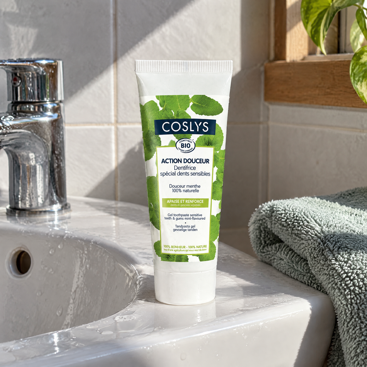 Coslys BIO Zahngel sensible Zähne & Zahnfleisch, 75 ml – auf dem Rand eines Keramik-Waschbeckens neben einem Tuch